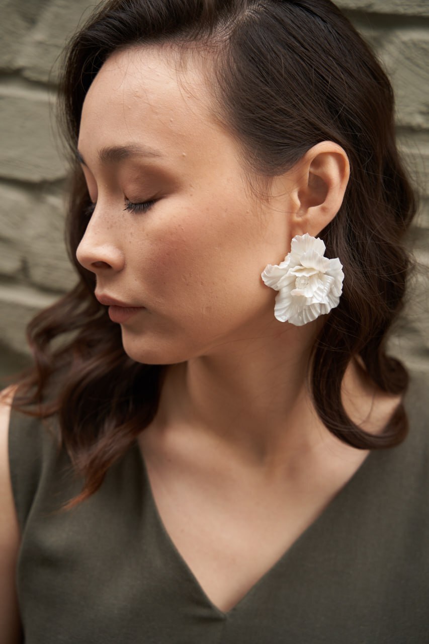 Woman wearing a white floral Yoli earring