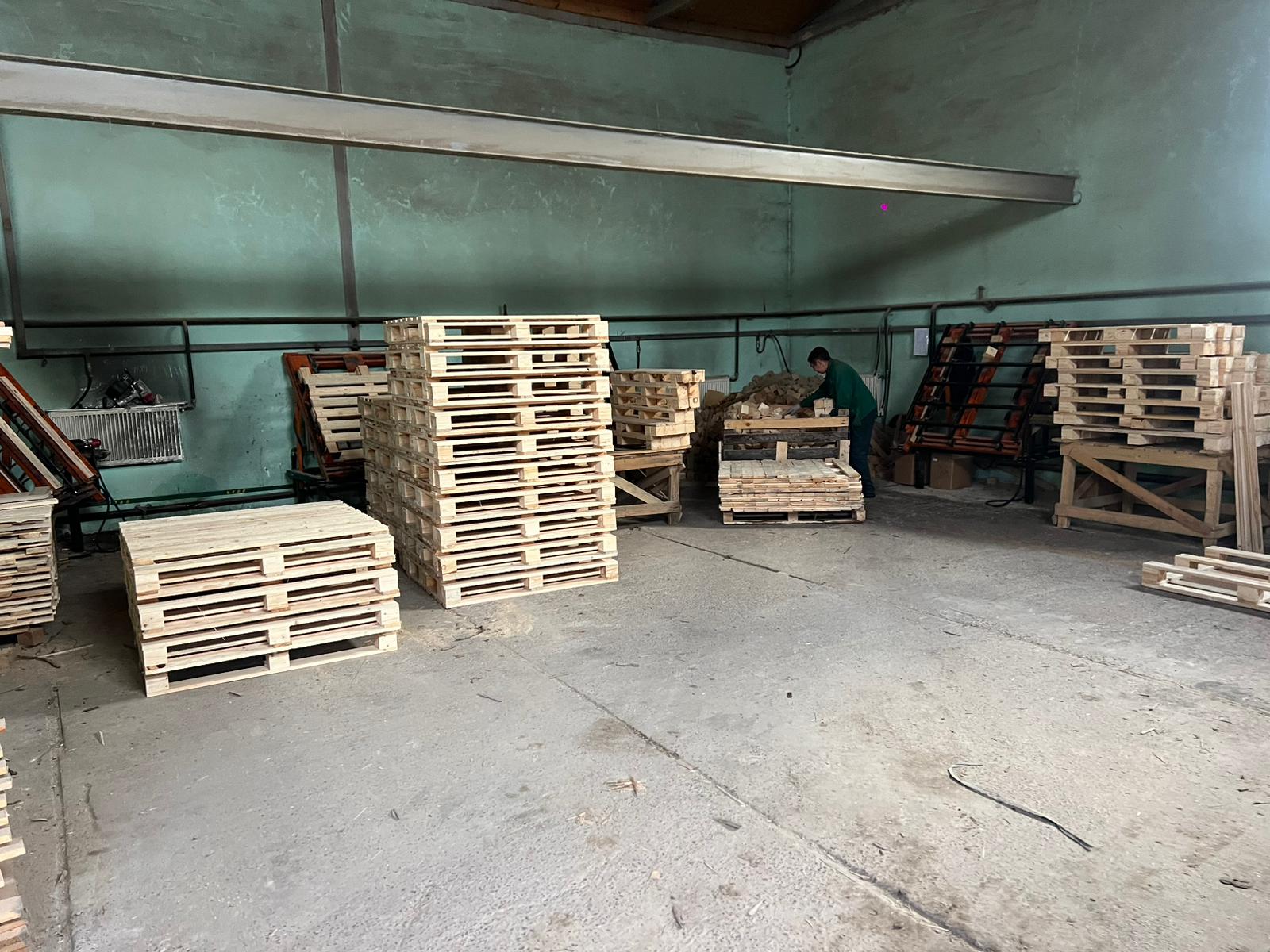Carpenter assembling wooden pallets in a workshop