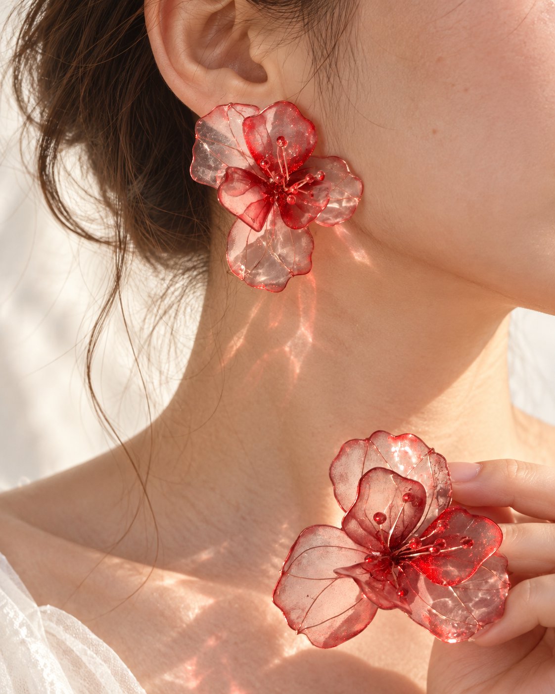 Translucent red floral jewelry worn at the ear
