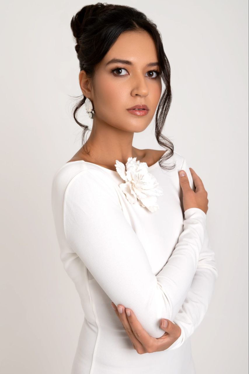 Bride in white wearing a statement flower piece