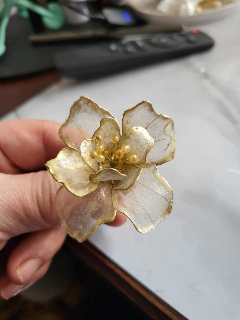 A handmade flower held during the making process