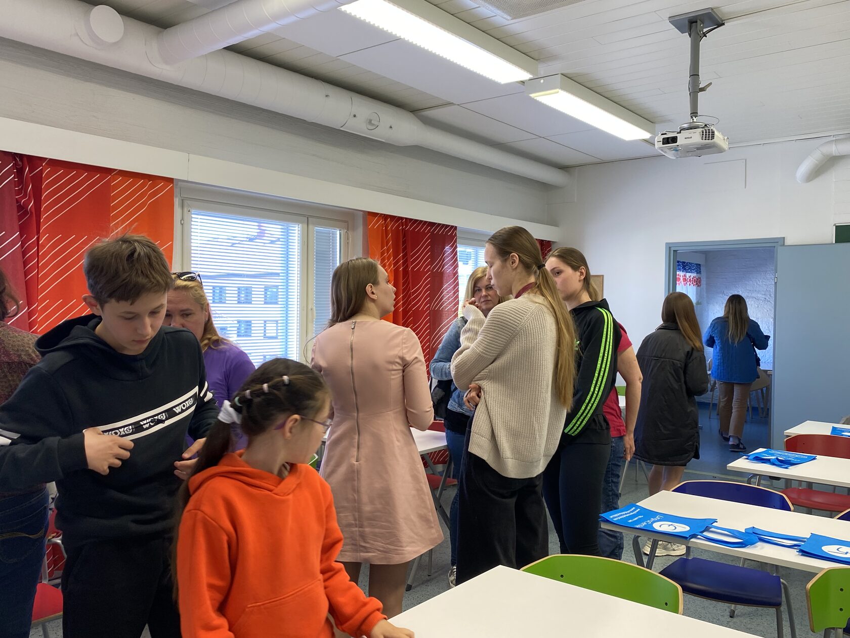 Children and adults in a bright classroom at the Lingvo Center language school
