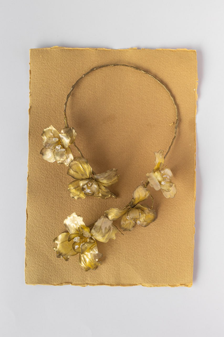 Golden botanical necklace photographed in full