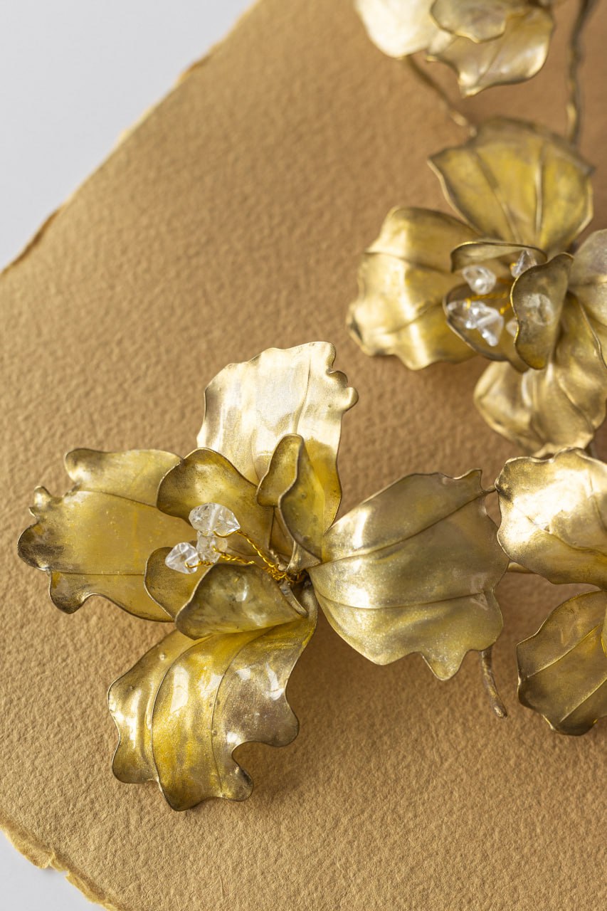 Close detail of a golden botanical necklace